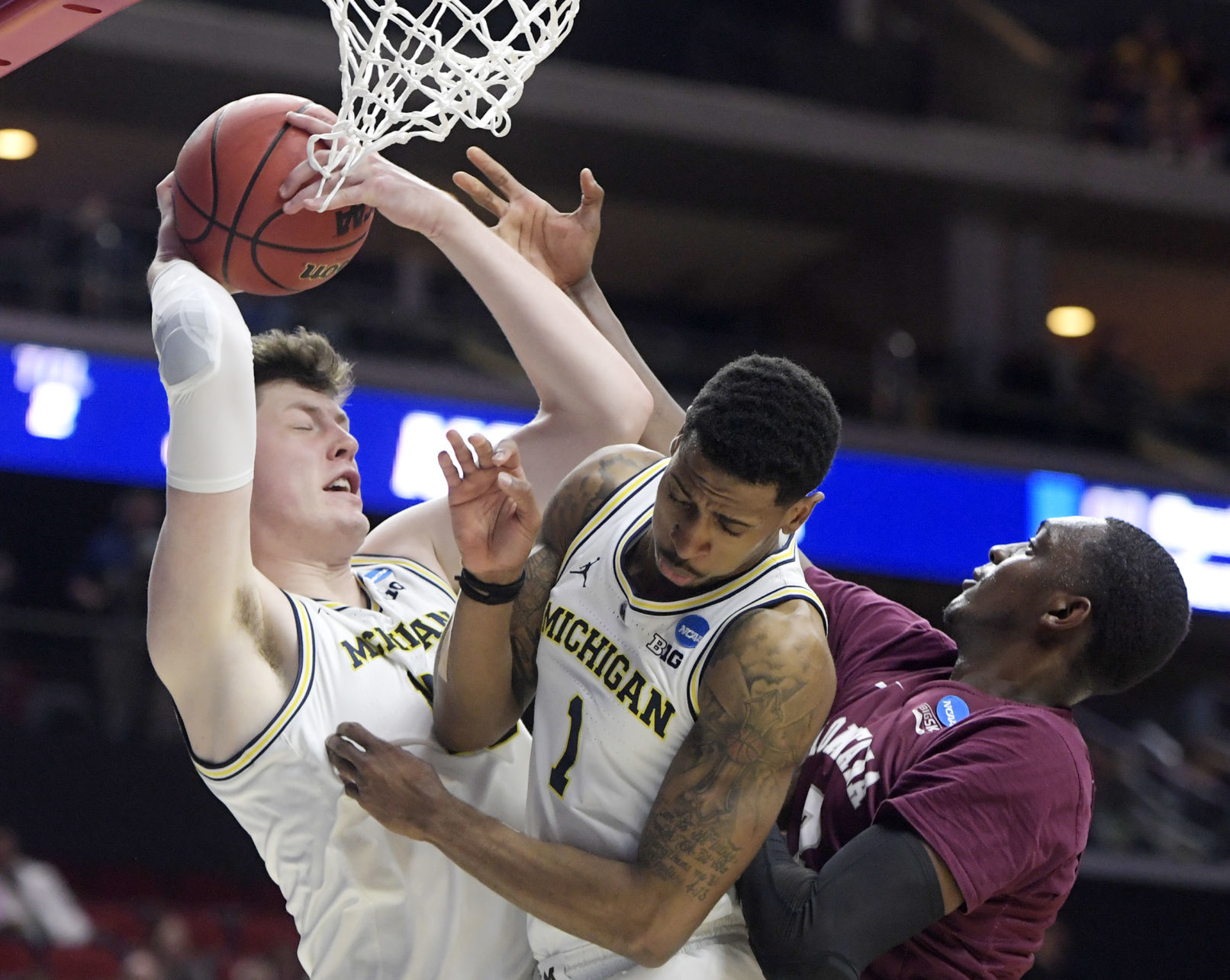 Michigan's Jon Teske pulls down a rebound